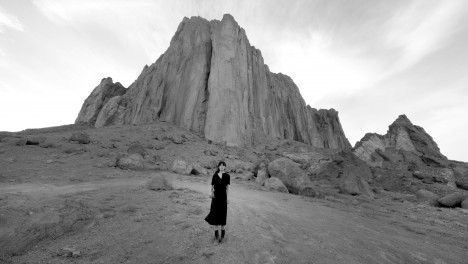 在新墨西哥州一个岩石景观前的女人的视频。Shirin Neshat，《梦想之地》视频，2019年。